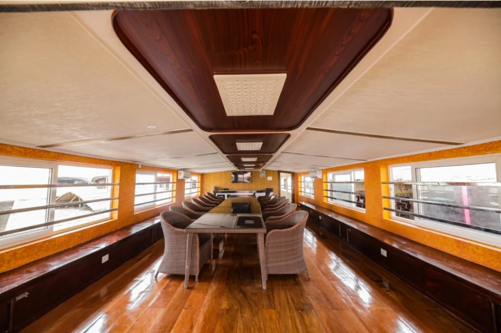 Grand 16-seat dining and conference hall with wood ceilings, panoramic windows, and wicker chairs