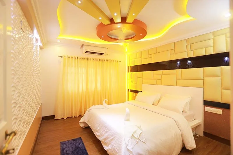 Executive AC bedroom with yellow acoustic block-quilted headboard wall, sculpted floral ceiling rosette, and wave panels