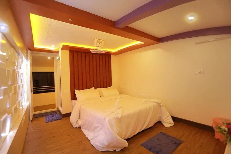 Deluxe AC stateroom with fluted terracotta padded headboard, cove ceiling illumination, and 3D textured accent wall