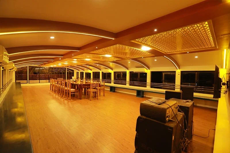 Upper event deck perspective showing wooden dance floor, sound system equipment, and panoramic glass windows